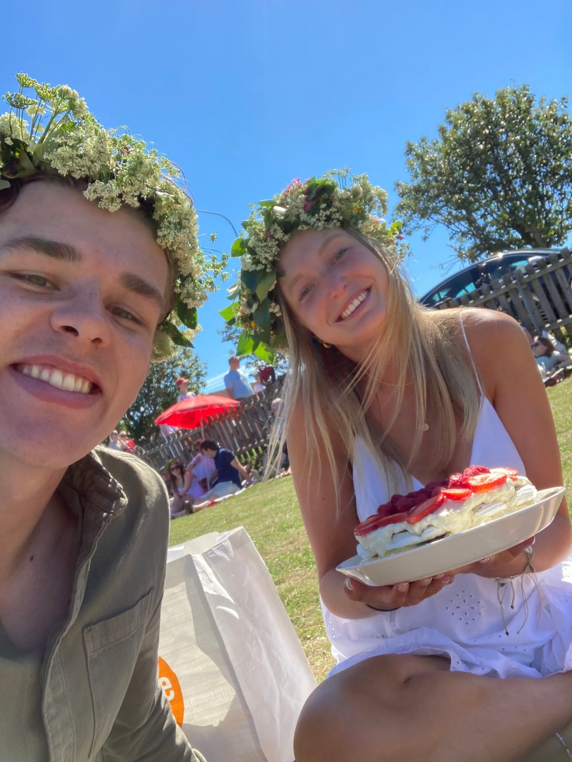 Filip och Josefin med blomsterkransar och picknick i gräset